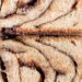 Close-up of a hand holding delicious chocolate babka slices with swirled patterns.