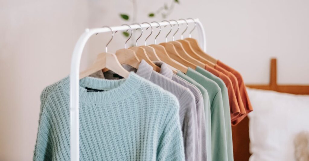 Chic bedroom interior featuring a stylish clothing rack with cozy sweaters in earthy tones.